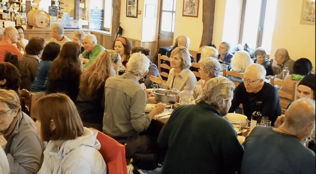 people at long tables eating a meal on the Camino